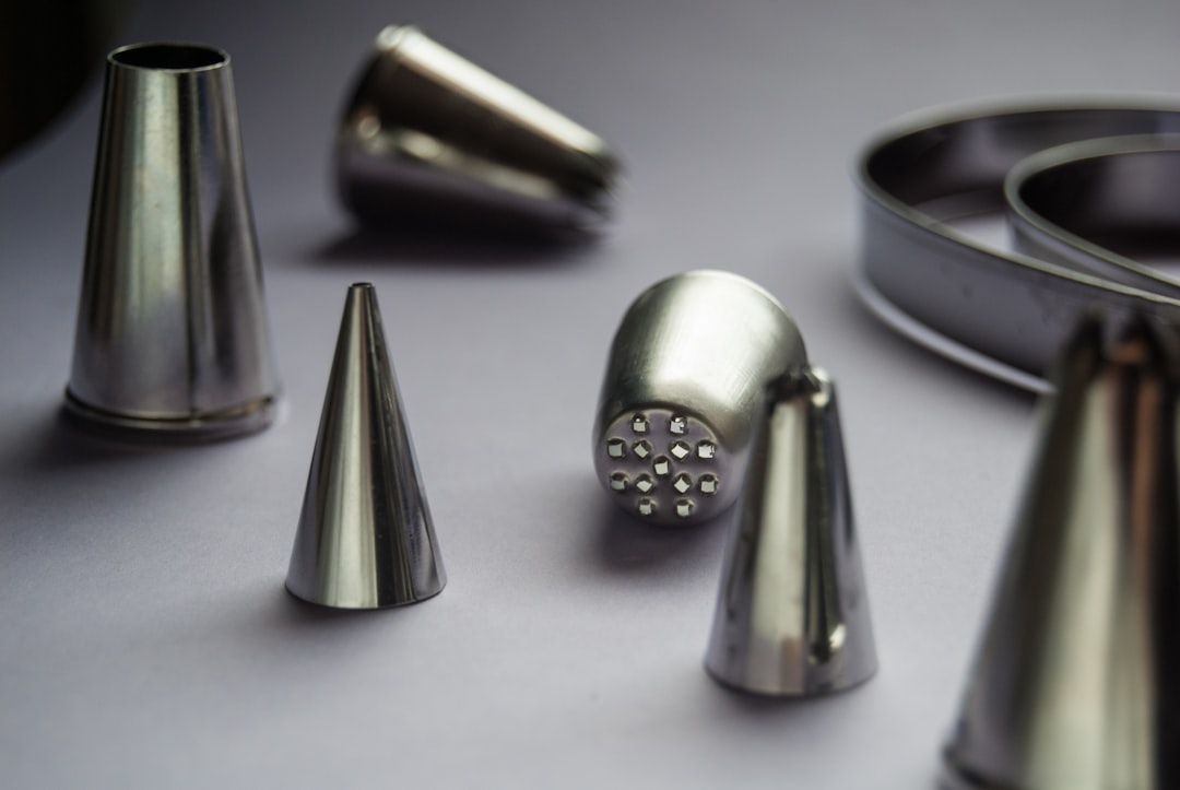 Various cake decorating piping tips on a gray background.